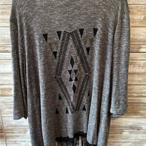 Gray cardigan with black tassels at bottom and a Aztec print on back.